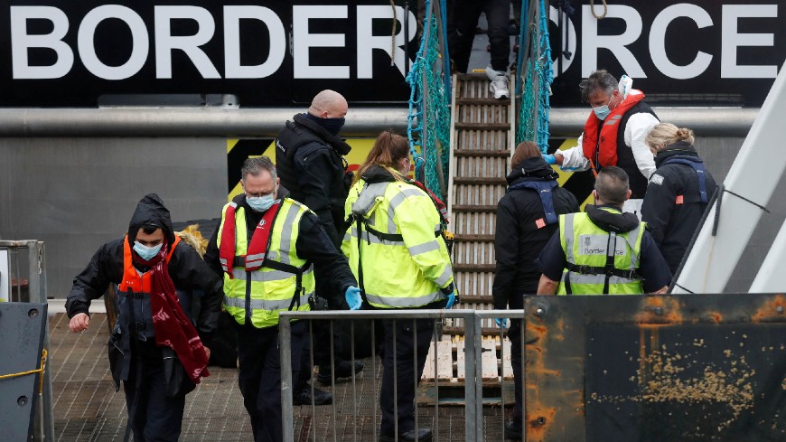Les migrants arrivés à bord d'un bateau de sauvetage des forces frontalières sont escortés par le personnel des forces frontalières, après avoir traversé la Manche, au port de Douvres, au Royaume Uni, le 15 décembre 2021. Crédit: REUTERS/Matthew Childs