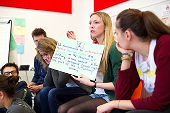Photo on the Home page, young people listening to a presentation by a group member